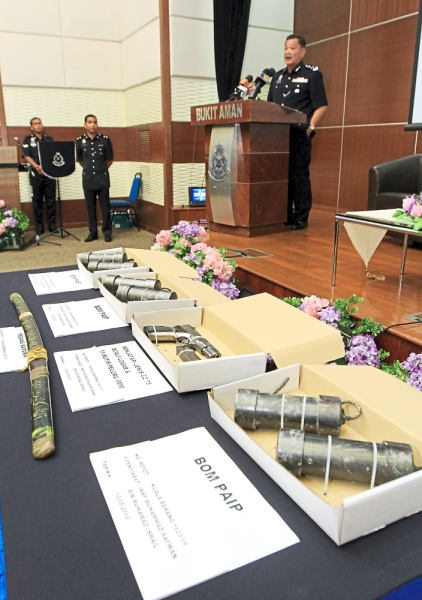 Swift action: Abdul Hamid addressing the media at a press conference with the weapons and explosives seized from the terrorists. 