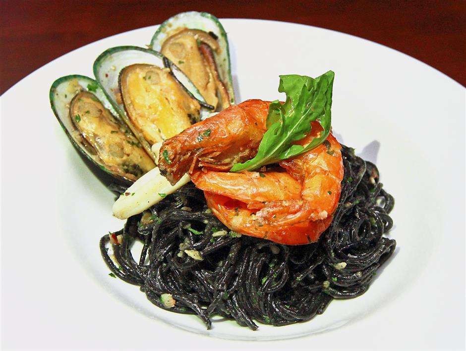 Squid Ink Spaghetti sauteed in olive oil, garlic and chilli, topped with mussels, squid and prawns.