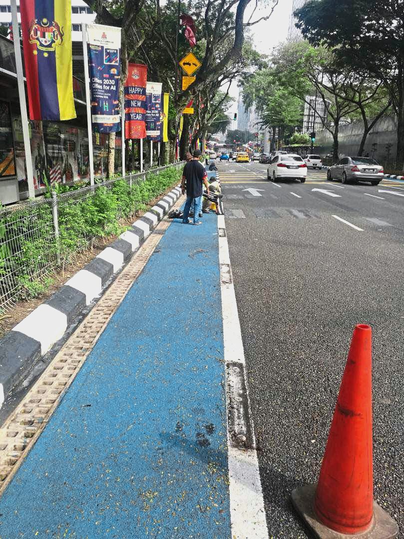 DBKL workers removing the bicycle lane separators following objections and a viral photograph showing an injured motorcyclist whose vehicle hit the black divider intended to protect cyclists and keep motor vehicles out. —Photo courtesy of DBKL