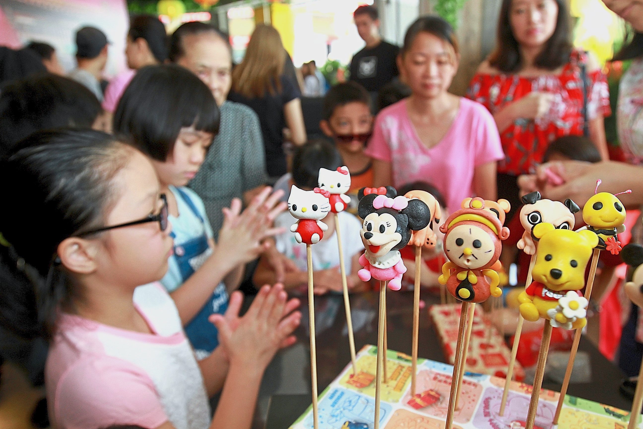 Children trying their hand at making candy puppets.