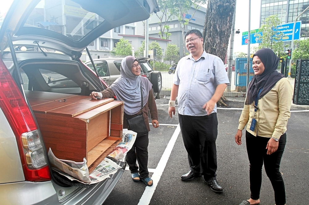 Rohani Kasim (left) taking home a discarded cupboard purchased from the PJ Eco Recycling Plaza for RM30. The cupboard was among items thrown away and was collected by MBPJ. She is seen here speaking with Lee about the centre’s purpose.