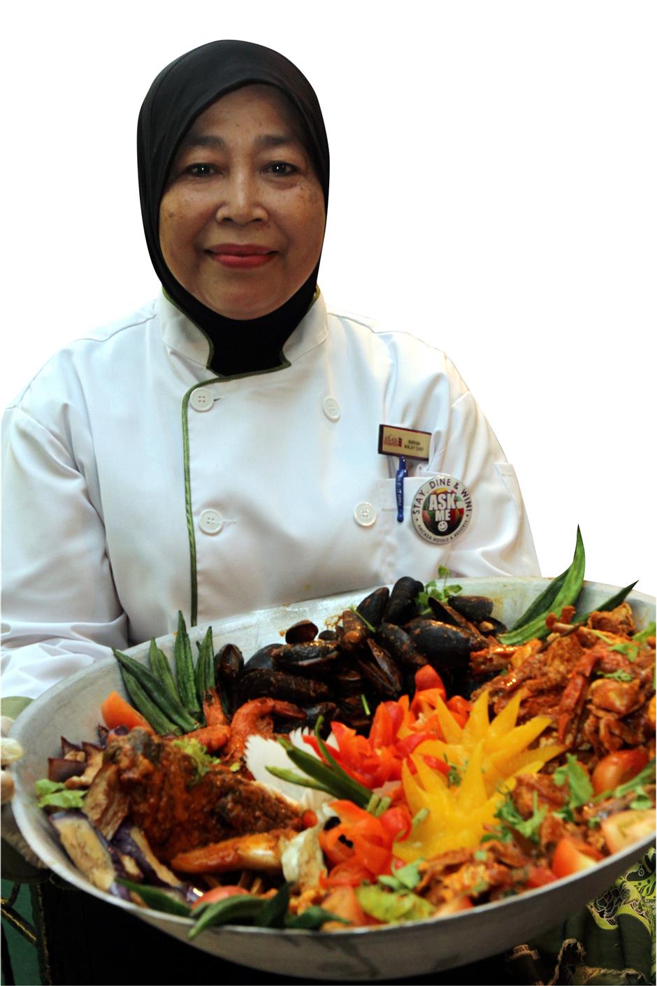 (Left) Mariam with her seafood kandar dish. — Photos: LOW LAY PHON/The Star