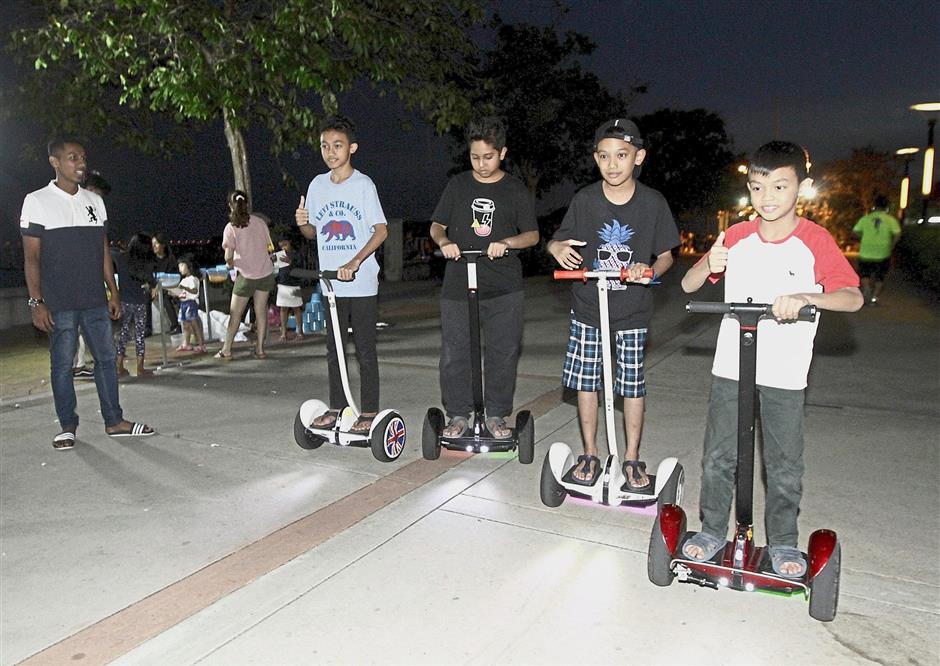 Mohd Andy Hakimi Abdullah (second from right), 10, and his friends enjoying their rides on Ninebot scooters.