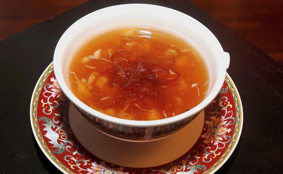 The Double-Boiled Sharks Fin Soup with Crabmeat and Assorted Seafood is a chicken-based broth with a generous sprinkling of handmade sharks fin.