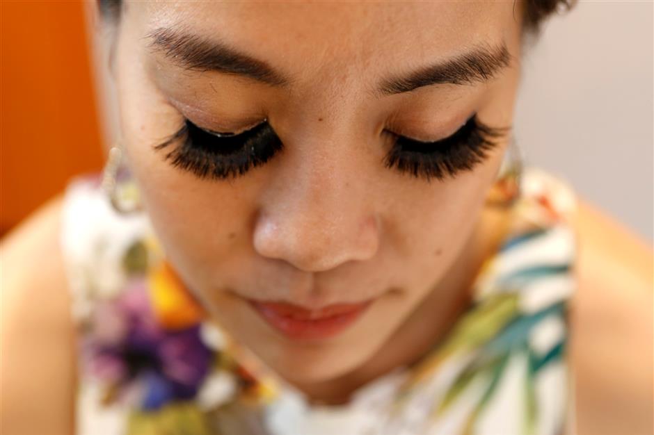 A woman wears fake eyelashes by e-commerce brand Bohktoh in Bangkok, Thailand June 12, 2019. Picture taken June 12, 2019. REUTERS/Jiraporn Kuhakan NO RESALES. NO ARCHIVES.