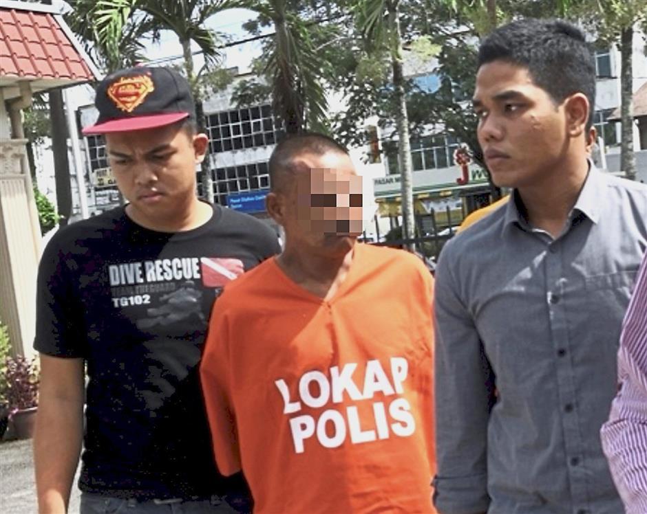 Under lock and key: The suspect being taken into custody after the incident.
