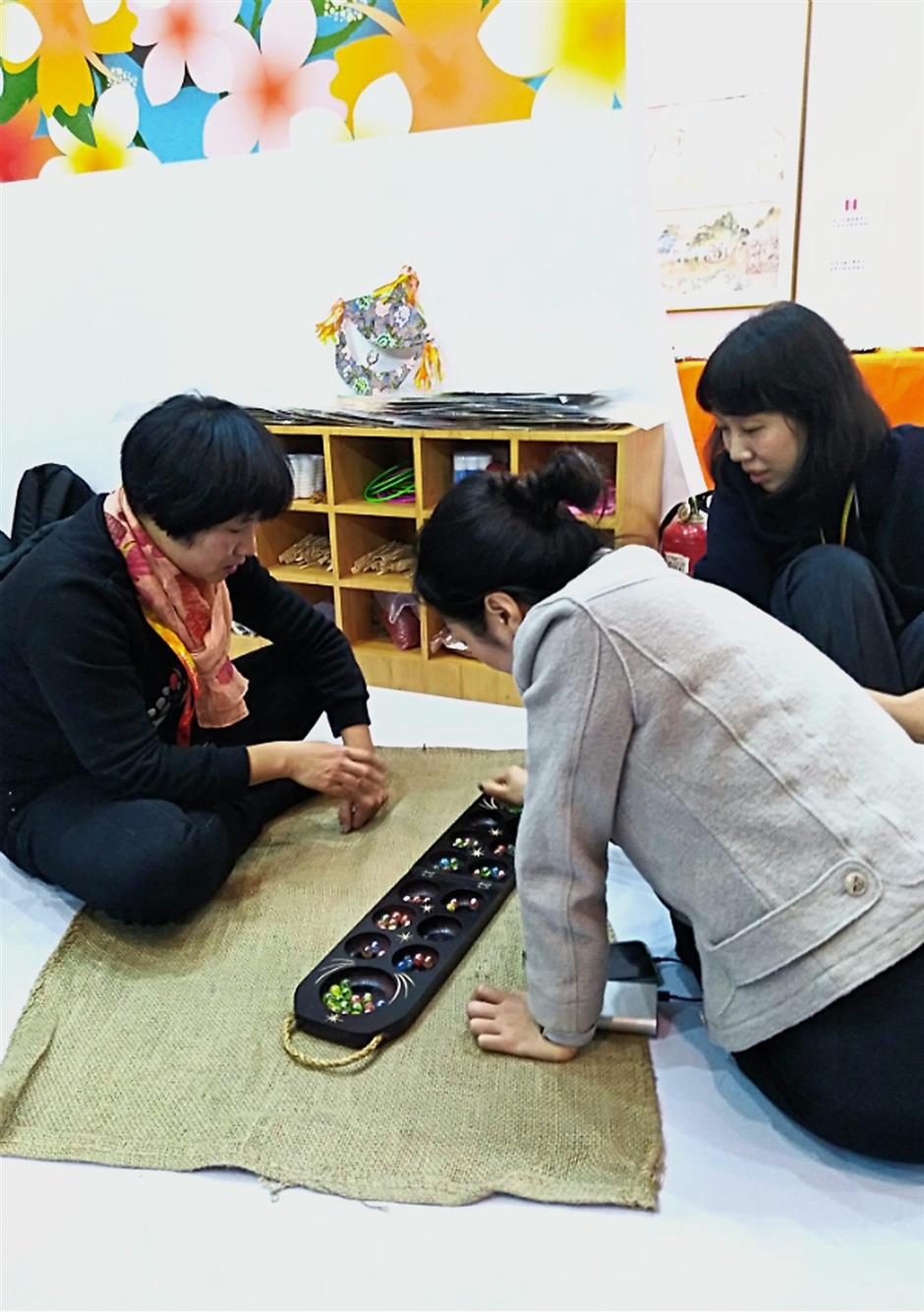 Traditional game: Visitors learning to play the congkak at the expo.