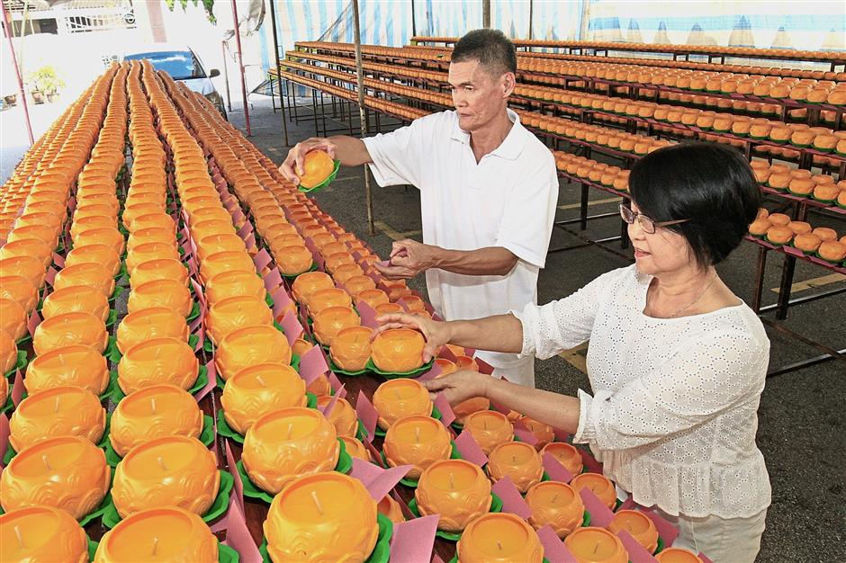 Lim (right) and Sunny Foong, both 60, arranging the candles for the Wesak Day celebrations.