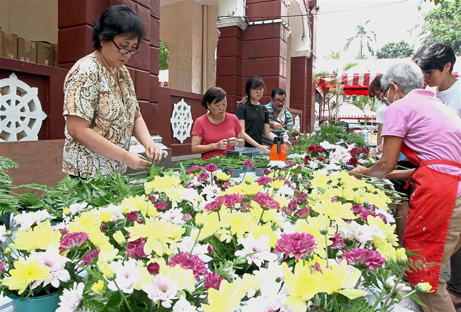 Volunteers preparing flowers for devotees to pick up when placing donations at Buddhist Maha Vihara temple in Brickfields.