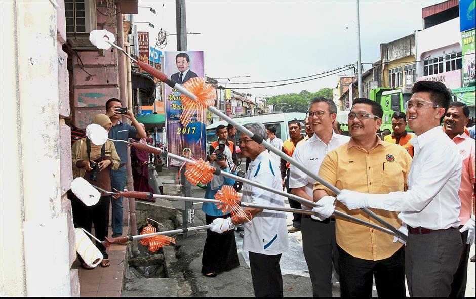 Deputy Education Minister Datuk Chong Sin Woon (right) painting the facade of an almost century-old shop located in old Nilai in a campaign to ’beautify’ the town recently. – filepic