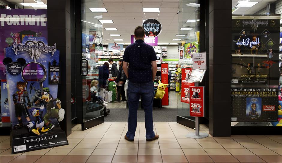 In this Dec. 9, 2018 photo, a 27-year-old self-described tech addict poses for a portrait in front of a video game store at a mall in Everett, Wash. He asked to remain anonymous because he works in the tech industry and fears that speaking out about the negatives of excessive tech use could hurt his career. 'If we get to a point in the tech industry where I can use my name and show my face in cases like this, thence've gotten somewhere. That'll be a turning point.' (AP Photo/Martha Irvine)