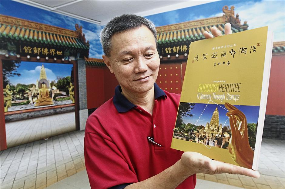 Hor showing the book on Leong’s stamps collection entitled ‘Buddhist Heritage: A Journey Through Stamps’ which includes photos and explanation of stamps featured at the Buddhist stamps gallery in Yayasan Belia Buddhist Malaysia in Penang.