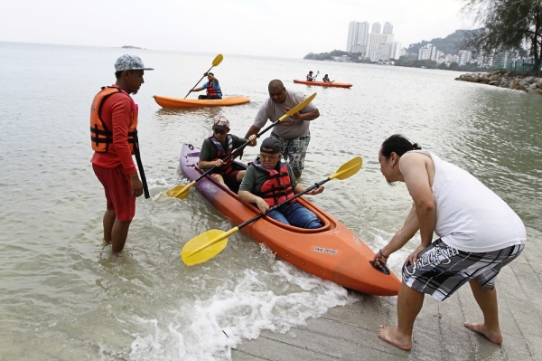 The Special Scouts were paired up with regular scouts while canoeing at Penang Water Sport Recreation Centre.(Right) Participants and volunteers playing bubbles at the camp.