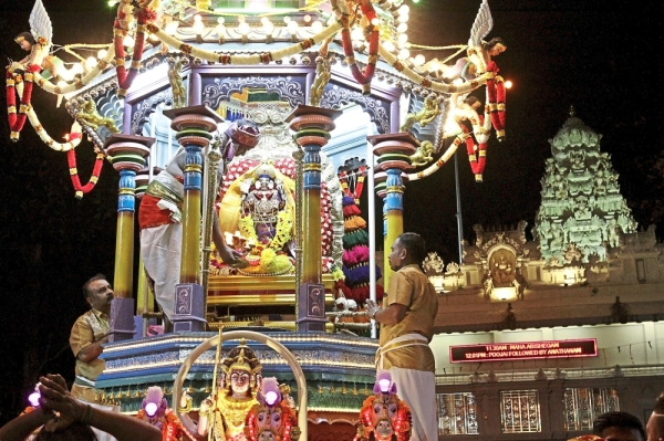 Devotees placing the statue of Lord Muruga onto the chariot.