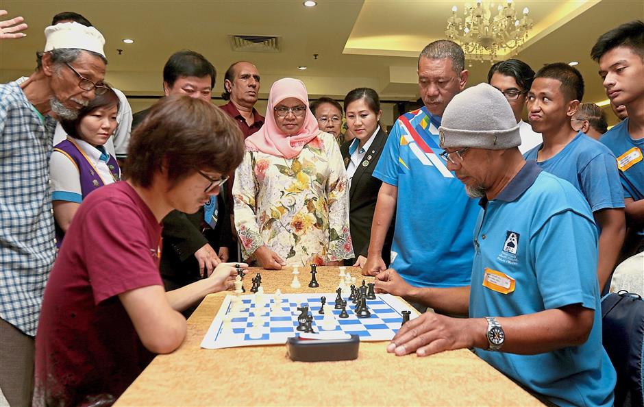 Maimunah (center) watching the final game between Tan (left) from Penang and Wan Mohd Ali from Perak during the 1st Malaysia Lions International Chess Championship for the Disabled (Northern Zone) at Lot 33 in Prangin Mall, Penang.